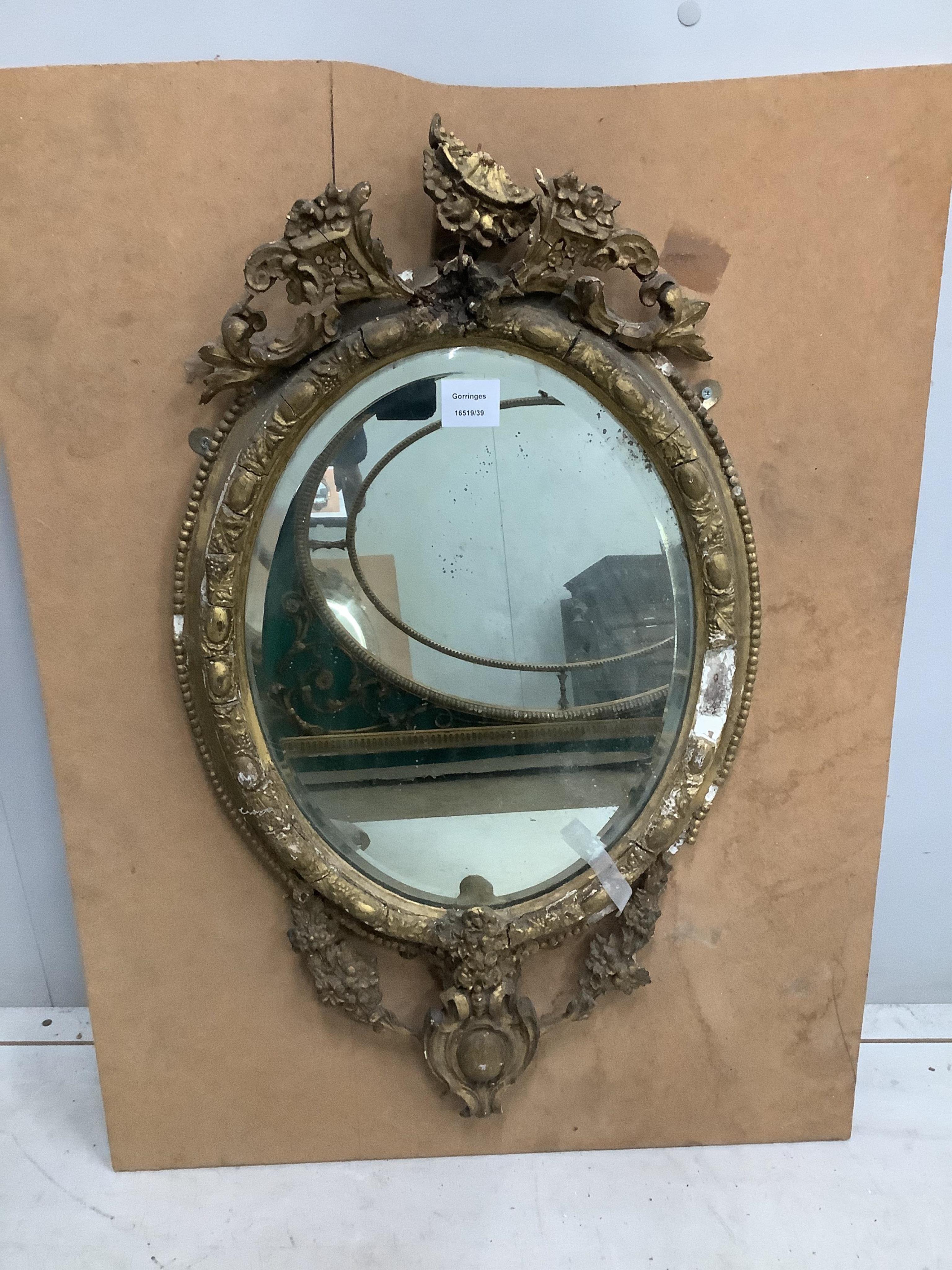 A pair of Victorian oval giltwood and gesso wall mirrors, in need of restoration, width 45cm, height 75cm. Condition - poor, in need of restoration